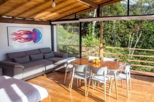 sala de estar con sofá, mesa y sillas en Casa el Ocobo, proyecto ecodependiente, en Silvania