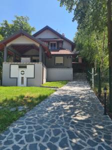 a house with a stone walkway in front of a house at Vila Dimitrijevic Lisine in Despotovac