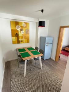 ein Esszimmer mit einem Tisch und einem Kühlschrank in der Unterkunft Ruhige Ferienwohnung in Rostock