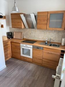 a kitchen with wooden cabinets and a sink at Ruhige Ferienwohnung in Rostock