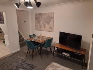 a dining room with a table with chairs and a television at 93 Newtown Road in Great Malvern