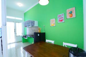 cocina con mesa y pared verde en Villa Casa Blanca by Masterpiece Villa, en Batu