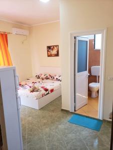 a bedroom with a bed and a bathroom with a toilet at Vila zaho in Dhërmi