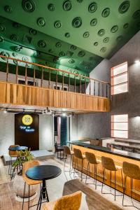Cette chambre est dotée d'un plafond vert avec des tables et des chaises. dans l'établissement JO&JOE Rio de Janeiro Largo do Boticario, à Rio de Janeiro