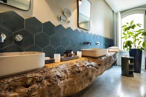 a bathroom with a large sink and a tub at Donna Carmela Resort & Lodges in Riposto