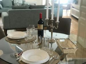 un tavolo di vetro con una bottiglia di vino e bicchieri di KNEZ SIMA Jacuzzi, 3 Bedrooms, Balcony in STARI GRAD a Belgrado