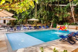 uma piscina com cadeiras e guarda-sóis em JO&JOE Rio de Janeiro Largo do Boticario no Rio de Janeiro