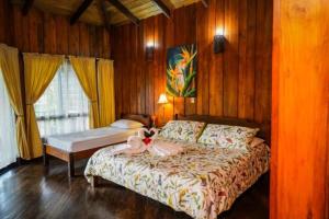 un dormitorio con una cama con un animal de peluche en Heliconias Rainforest Lodge, en Bijagua
