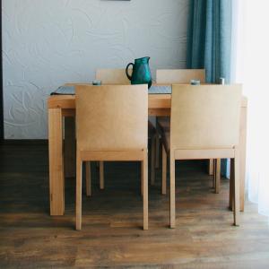 - une table en bois avec 2 chaises et un vase dans l'établissement Ovruč Apartments Štrbské Pleso, à Štrbské Pleso
