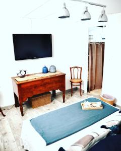 uma sala de estar com uma televisão e uma mesa em MAGNOLIA HOME 32 em Auch