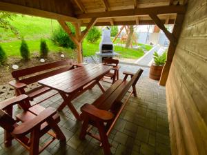 a wooden table and chairs on a patio with a grill at Domek całoroczny "U Haliny'' in Mutne