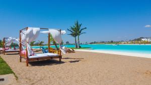 a group of chairs on the beach near the water at Sun Cottage - Mar Adentro in Santa Cruz de la Sierra