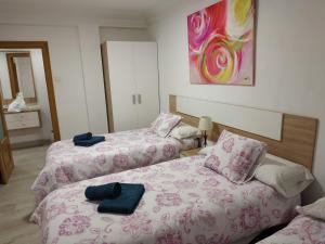 two beds in a hotel room with towels on them at apartamento Miñes in Zaragoza