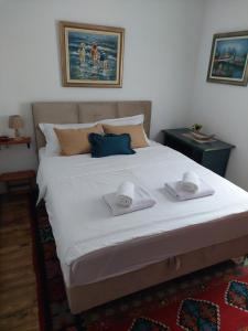 a bedroom with a large bed with two towels on it at Green Eco Cottage in Kolašin