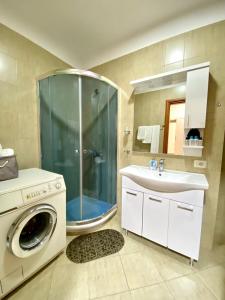 La salle de bains est pourvue d'une douche, d'un lavabo et d'un lave-linge. dans l'établissement Chlo apartment 2 Tirana, à Tirana