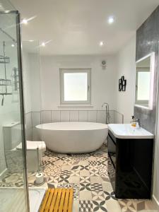 y baño con bañera, 2 lavabos y ducha. en Bright 2-bedroom apartment with parking in Montrose, en Montrose