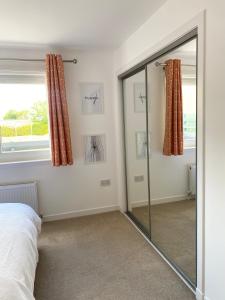 a bedroom with a glass shower door and a window at Bright 2-bedroom apartment with parking in Montrose in Montrose