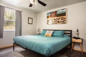 1 dormitorio con 1 cama con edredón azul y ventana en Carson Cabin - King Beds, Mountain Views, Mins to Town, en Red River
