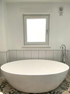 a white bath tub in a bathroom with a window at Bright 2-bedroom apartment with parking in Montrose in Montrose