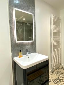 y baño con lavabo blanco y espejo. en Bright 2-bedroom apartment with parking in Montrose, en Montrose