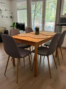- une table et des chaises en bois dans le salon dans l'établissement Het Natuurhuisje op de Veluwe, à Nunspeet