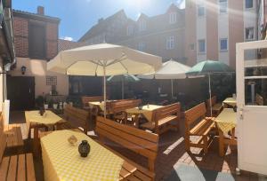 a patio with tables and umbrellas on a building at Altenceller Tor, Hotel & Restaurant in Celle