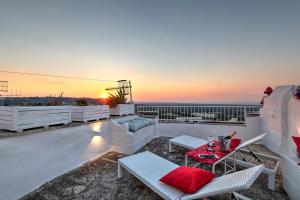 un patio en la azotea con mesa, sillas y puesta de sol en Loft Parisi, en Ostuni