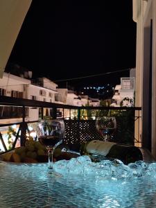 two wine glasses sitting on top of a table at Green Suite Skiathos in Skiathos +17 photos