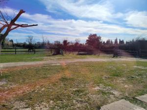 un campo de hierba con una valla y un árbol en Appartement indépendant proche Étang de l'Olivier, en Istres