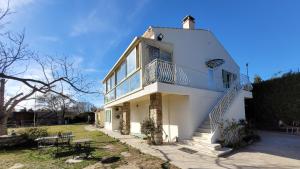 Casa blanca con escaleras y balcón en Appartement indépendant proche Étang de l'Olivier, en Istres