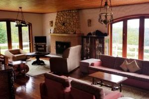 a living room with a couch and a fireplace at Alto do Capivari - Gramado e vista espetacular in Campos do Jordão