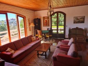 a living room with red couches and a table at Alto do Capivari - Gramado e vista espetacular in Campos do Jordão +63 photos