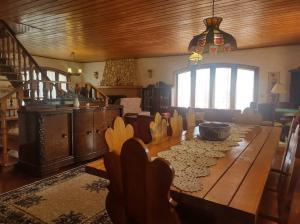 a dining room with a wooden table and a kitchen at Alto do Capivari - Gramado e vista espetacular in Campos do Jordão
