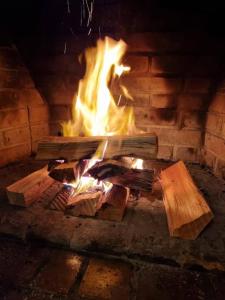 a fire in a brick oven with logs in it at Alto do Capivari - Gramado e vista espetacular in Campos do Jordão