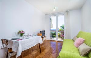 comedor con mesa y sofá verde en 2 Bedroom Awesome Apartment In Icici en Ičići