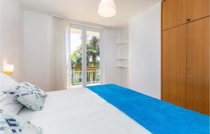 1 dormitorio con 1 cama blanca grande y ventana en 2 Bedroom Awesome Apartment In Icici en Ičići
