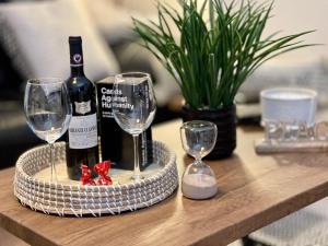 a tray with a bottle of wine and two glasses on a table at Delightful 2 bed detached home with secure parking in Huntington