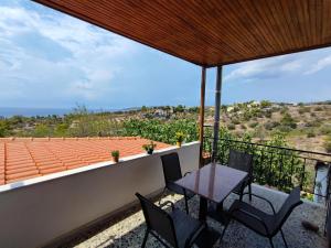 a patio with a table and chairs on a balcony at THOMAS VIEW Εξοχικό σπίτι με θέα στη θάλασσα in Porto Heli