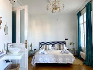 sypialnia z łóżkiem, umywalką i żyrandolem w obiekcie Apartamento en el centro de Bilbao w mieście Bilbao