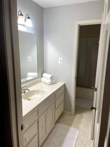 a white bathroom with a sink and a mirror at Cozy & spacious 4 bed home with indoor fire place in Madison