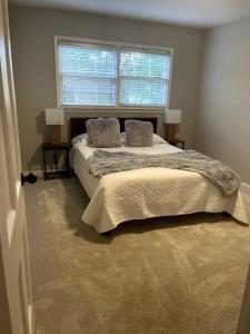 a bedroom with a bed with two pillows and a window at Cozy & spacious 4 bed home with indoor fire place in Madison