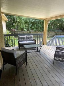 a porch with chairs and a couch and a table at Cozy & spacious 4 bed home with indoor fire place in Madison