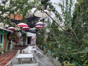 un patio con mesas y sombrillas rojas en House Marfito Airport en Cartagena de Indias
