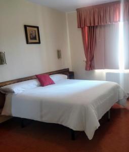 um quarto com uma grande cama branca e uma janela em Casa de mamá em Santiago de Compostela
