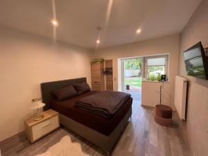 Schlafzimmer mit einem Bett und einem Flachbild-TV in der Unterkunft Nina Apartments in Mühlhausen