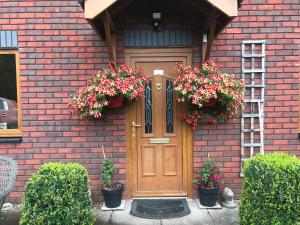 a brick house with two flower baskets on the door at Roselea in Glasbury