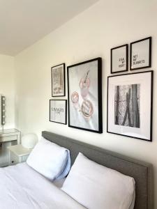 a bedroom with a bed with four pictures on the wall at Bright 2-bedroom apartment with parking in Montrose in Montrose