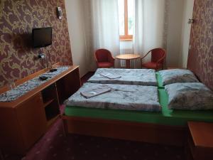 Habitación de hotel con 2 camas y escritorio en Dobrá škola u Jeníčka, en Vojkovice