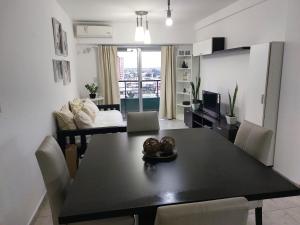 a dining room and living room with a black table and chairs at Dto Tejedor in Mariano J. Haedo