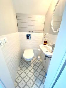uma casa de banho com um WC e um lavatório em White Wave Norda Dębki em Dębki